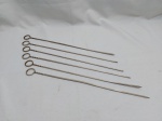 Jogo de 6 espetos em metal prateado. Medindo 39cm de comprimento.