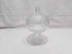 Compoteira redonda com tampa em vidro moldado. Medindo 16cm de diâmetro x 24,5cm de altura com tampa.