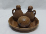 Galheteiro com 4 peças em cerâmica marrom, composto de 2 azeiteiros, saleiro e bandeja redonda. Medindo a bandeja 19,5cm de diâmetro x 3cm de altura.