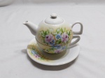Trio de chá com bule em porcelana branca, pintada à mão. Medindo 13cm de altura total.