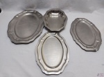 Baixela com 4 peças em aço inox Wolff, borda recortada. Medindo a travessa oval rasa maior 45cm x 31cm.