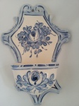 Recipiente para água benta com pintura à mão, floral em tom azul, confeccionado em faiança. Med. 24x17 cm.