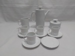 Jogo de servir café com 7 peças em porcelana Renner friso prata, pintura branca. Composto de 4 xícaras, 5 pires, bule, leiteira e açucareiro.