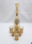 Lindo jogo de servir licor, aperitivo com garrafa e 6 copos em vidro âmbar decorado com flores e friso ouro. Medindo a garrafa 29,5cm de altura e os copos 6cm de altura.