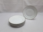 Jogo de 6 pratos de sobremesa em porcelana Schmidt com pintura branca e friso prata. Medindo 19,5cm de diâmetro. Sendo um com leve bicado.