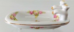 PORCELANA D&D - Delicada saboneteira em porcelana decorada por aplicações de rosas em bela policromia e detalhes em ouro. Mede 8 cm de altura por 19,5 cm de comprimento. 