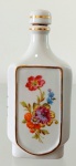 PORCELANA D&D - Delicada garrafa em porcelana decorada por aplicações de rosas em bela policromia e detalhes em ouro. Mede 16,5 cm de altura por 7 cm de comprimento. 