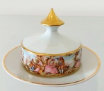PORCELANA D&D - Belíssima manteigueira em porcelana ricamente adornada por cenas galantes em policromia e pintura em ouro. Mede 10 cm de altura e 15 cm de diâmetro.