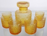 Jogo para licor contendo 7 peças em vidrão moldado e texturizado de tom âmbar sendo 1 garrafa com tampa e 6 copos. Medem 13,5 cm de altura por 10 cm de diâmetro a garrafa e 6 X 6 cm cada copo.
