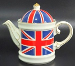 Bule em porcelana inglesa manufatura The great british pottery company decorado pela bandeira britânica e com pega da tampa em formato de coroa. Mede 15,5 cm de altura por 19 cm da alça ao bico.