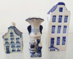 Lote composto por 3 peças holandesas em tons blue & white contendo: 2 casinhas (sendo uma Delft e uma Royal Delft) e uma mini floreira com figura de casal - com infimo bicado na borda. A casinha menor possui manchas. Maior medida 13,7cm de altura e menor medida 8cm de altura.
