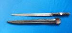 27 - ROBUSTO PUNHAL DE LÂMINA FORJADA COM BOTÃO PRIMITIVO  -  COMPRIMENTO 34,5 CM - LÂMINA COM 24,5 -  EMPUNHADURA EM SEÇÕES DE CHIFRE INTERCALADOS COM ANÉIS DE LATÃO - BAINHA ORIGINAL