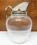 Elegante e antiga jarra executada em cristal de tonalidade translúcida, adornada por belíssima lapidação, alça e borda em metal prateado de ótima fundição. Mede 22 x 17 x 09 cm. Bom estado de conservação.