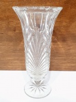 Elegante vaso floreiro executado finamente em cristal de tonalidade translúcida, adornado por rica lapidação, lindo trabalho na base e borda. Mede 21 cm de altura x 10 cm de diâmetro. Perfeito estado de conservação.