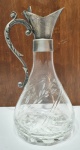 Antiga e elegante jarra executada finamente em cristal de ótima qualidade em tonalidade translúcida, ricamente lapidada com detalhes jateados, taampa abre-fecha em metal prateado com pega trabalhada. Mede 26 cm de altura x 13 cm de diâmetro da base. Bom estado de conservação, tampa abre-fecha no estado.