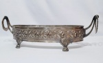 Majestosa e elegante floreira finamente trabalhada em metal espessurado á prata de excelente fundição e qualidade, riquíssima ornamentação floral sustentada por quatro pés firmes ditos pata de leão. Perfeito estado de conservação. Mede 16 x 55 x 20 cm.