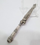 CORNETA -Linda faca gaúcha, lâmina em aço inoxidável nobre de ótima fundição, rico trabalho floral na bainha e cabo em metal espessurado á prata. Mede 29 cm de comprimento. Bom estado de conservação. Se encontra entupida com papel dentro, deixando 01 cm da lâmina para fora.