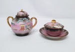 MARCA REGISTRADA H - Lote composto por açucareiro e manteigueira em porcelana dita Satsuma, finamente decorada em relevo com cena oriental e rica cobertura a ouro. Marca da preciosa manufatura H na base. Japão meados do séc. XX. Ambos em perfeito estado de conservação. Maior peça açucareiro mede 12 x 14 cm.
