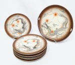 MARCA REGISTRADA H - JAPÃO - Clássico conjunto para sobremesa em porcelana dita Satsuma, ricamente decorada em relevo com dragões e filetes á ouro. Composto por seis pratos rasos (19 cm diâm. cada) e um prato raso para doce medindo 25,5 cm de diâmetro. Perfeito estado de conservação. Japão meados do Século XX.