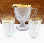 Elegante e clássico lote composto por uma jarra e dois copos, executados finamente em cristal de tonalidade translúcida ricamente lapidadas com motivo dito bico de jaca, cobertura á ouro na borda e rica lapidação na haste. Jarra mede 20,5 x 20,5 x 14 cm. Copos medem 12,5 x 08 cm cada. Bom estado de conservação.