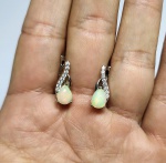 Belíssimo Par de brincos em prata de lei espessurada a ouro branco, design moderno exclusivo de excepcional ourivesaria com linda Opala de fogo de 7.0 x 5.0 mm , clássica lapidação gota cabochon, adornada por rico trabalho e rica incrustação de Zirconias. perfeito estado de conservação, medem 1,6 x 0,6 cm . Origem Etiópia.