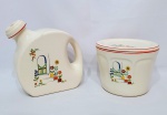 NATIONAL BROTHERHOOD OPERATIVE POTTERS - CAMBRIDGE - EUA - Raro conjunto em cerâmica, composto por uma bela biscoiteira e uma elegante moringa, decoradas com linda ornamentação floral pintada á mão. Marca da preciosa manufatura Brotherhood sobre a base. Estados Unidos meados do século XX. Bom estado de conservação. Biscoiteira 12 x 16 cm, moringa 16 x 17 x 7,5 cm.