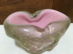 MURANO - Belíssimo centro de mesa em vidro artístico de Murano de linda tonalidade rosa, feitio com bolhas e pó de ouro, adornado por rico movimento e linda borda. Perfeito estado de conservação. Mede 10 x 17 cm.