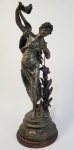 V. CONSTANTIN  AURORE  LINDA ESCULTURA EM PETIT BRONZECOM PERSONIFICAÇÃO DA AURORA. FRANÇA, FINAL DO SEC. XIX. 70 CM DE ALTURANOTA: AURORA OU EOS na mitologia grega, é a deusa que personificava o amanhecer. Filha de Hiperião e Teia, é a irmã da deusa Selene, a Lua, e de Hélio, o Sol. Eos tem, como principal função, abrir as portas do céu para a carruagem de Hélio, a personificação do Sol, sendo assim a deusa do amanhecer (Quando a carruagem de Hélio está saindo, e o Sol está nascendo) e do entardecer, mais especificamente, o pôr do sol (Quando a carruagem de Hélio está voltando, e o Sol está se pondo). Responsável também pelo brilho do Sol e das tonalidades do Céu, Eos é a deusa que desperta as pessoas e criaturas dos mais profundos sonhos e derrama orvalho nas folhas, sendo mais conhecida por ser a deusa especialmente do amanhecer. São numerosas as paixões de Eos, sendo a mais conhecida com Titono, irmão mais velho de Príamo. Ao apaixonar-se por ele, teve medo de o perder e o raptou e levou-o para a Etiópia.A deusa amava-o tanto que pediu para que lhe concedessem a imortalidade, mas esqueceu-se da juventude eterna, e dessa forma o amado da deusa transformou-se num velho decrépito, sem nunca, no entanto, morrer. Eos decidiu, então pedir para que Zeus o transformasse numa cigarra.Com Titono, teve dois filhos: Emátion e Mêmnon.Céfalo, filho de Hermes e Herse, também foi vítima do amor implacável de Eos.Ele estava já casado com a princesa Prócris, terna e amorosa e sempre fiel a seu marido.Insaciável como sempre, Eos pouco se importa para o sofrimento de Prócris e rapta Céfalo enquanto caçava nas proximidades do monte Imeto.Mas apesar de todos os esforços da deusa, o jovem continua apaixonado por sua esposa. Apesar de muitos esquemas ardilosos da deusa, Céfalo e Prócris se reconciliam. Céfalo volta a caçar, mas sua esposa, com receando a deusa rival, o segue. Pensando se tratar de um animal, ele a mata e ao ver o que havia feito, se joga ao mar. Comovido, Zeus os transforma em estrelas.Uma das versões do mito de Ganímedes, conta que ele foi raptado e levado ao monte Olimpo não por Zeus, mas pela deusa Eos, ao que parece essa era a versão original do mito de Ganímedes, ela é mencionada por Apolonio de Rodis, e outros escritores da Grecia antiga.1As suas paixões atribuem-se ao fato de que teve amores com Ares, algo que deixou Afrodite muito enciumada, fazendo com que lançasse um feitiço sobre Eos, para que ela se apaixonasse apenas por homens mortais, e tivesse um desejo sexual insaciavel.