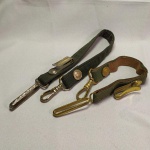 MILITARIA - PAR DE GUIAS DE ESPADAS MILITARES, EXÉRCITO BRASILEIRO, CONFECCIONADAS EM LONA E COURO, UMA COM FERRAGENS DOURADAS E COM 34 cm, A OUTRA COM FERRAGENS PRATEADAS E COM 46 cm.