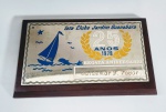 Placa comemorativa aos 25 anos da regata de aniversário do iate clube Jardim Guanabara - Ano 1978 - Placa em aço com detalhes esmaltados sobre madeira nobre - Possui gravação de nome - Medida:  14  x  8,5  x  1 cm.