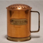 Polvilhador de queijo, de metal dourado com alça e inscrição CHEESE. Medida aproximada: 12 cm de altura.
