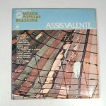 Vinil  Assis Valente  Nova história da Música Popular Brasileira. Produto Original. Gravadora Abril Cultura.  Fabricado e distribuído por RCA Eletrônica Ltda.  1977. Capa (danificada com desgastes do material,  escurecida e com pontos de oxidação)/contracapa (danificada com desgastes do material e escurecida) em regular estado de conservação, danificada nas bordas colada com fita adesiva transparente, manchas/pontos de oxidação, marcação do disco, com sinais de uso, manuseio e desgastes. Não contém plástico de proteção do disco. Disco com riscos, mesmo que superficiais podem ocasionar algum nível de ruído na audição. Contém envelope encarte. Lado A  4 faixas; Lado B   4 faixas.