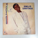 Vinil  Emílio Santiago  Aquarela Brasileira - 3. Produto Original. Gravadora Som Livre. Fabricado e distribuído por SIGLA  Sistema Globo de Gravações Audiovisuais Ltda. 1990. Capa (escurecida, com pontos de oxidação, etiqueta colada, assinatura/rasuras e com desgastes do material)/contracapa (com pontos de oxidação, escurecida e danificada nas pontas) em regular estado de conservação, danificada nas bordas, manchas/pontos de oxidação, marcação do disco, com sinais de uso, manuseio e desgastes. Não contém plástico de proteção do disco. Disco com riscos, mesmo que superficiais podem ocasionar algum nível de ruído na audição. Não contém encarte. Lado A  5 faixas; Lado B   5 faixas.