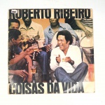 Vinil  Roberto Ribeiro  Coisas da vida.  Produto Original. Gravadora EMI. Fabricado e distribuído por EMI-Odeon. 1979. Capa (com etiqueta colada, escurecida, com pontos de oxidação, rasuras  e desgastes do material)/contracapa (com pontos de oxidação, escurecida e com desgastes do material) em regular estado de conservação, danificada nas bordas colada com fita adesiva transparente, manchas/pontos de oxidação, marcação do disco, com sinais de uso, manuseio e desgastes. Não contém plástico de proteção do disco. Disco com riscos, mesmo que superficiais podem ocasionar algum nível de ruído na audição. Não contém encarte. Selo fonográfico com assinatura. Lado A  6 faixas; Lado B   6 faixas.