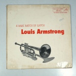 Vinil  Louis Armstrong  A rare batch of satch.  Produto Original. Gravadora RCA. Fabricado e distribuído por RCA. Capa (desgastes do material, assinatura e marcas)/contracapa (com desgastes do material, pontos de oxidação e escurecida) em regular estado de conservação, danificada nas bordas colada com fita adesiva, manchas/pontos de oxidação, marcação do disco, com sinais de uso, manuseio e desgastes. Não contém plástico de proteção do disco. Disco com riscos, mesmo que superficiais podem ocasionar algum nível de ruído na audição. Não contém encarte. Lado A  6 faixas; Lado B   6 faixas.