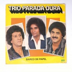 Vinil  Trio Parada Dura  Barco de papel. Produto Original. Gravadora Copacabana. Fabricado e distribuído por Som Indústria e Comércio S. A. 1984. Capa (com desgastes do material, cor, escurecida e com etiqueta colada)/Contracapa (com desgastes do material, cor, escurecida, pontos de oxidação e com rasuras) em regular estado de conservação, danificada nas bordas,  manchas/pontos de oxidação, marcação do disco, com sinais de uso, manuseio e desgastes. Contém plástico de proteção do disco, porém o mesmo está danificado. Disco com riscos, mesmo que superficiais podem ocasionar algum nível de ruído na audição. Não Contém encarte. Possui sinais de umidade. Lado A  6 faixas; Lado B   6 faixas.