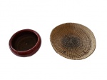 Cachepot em cerâmica na cor vinho e uma bandeja em palha, fundo manchado.  Diam. 24 e 39 cm.
