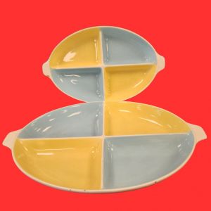NADIR FIGUEIREDO - Lindo par de petisqueira, da manufatura Nadir Figueiredo década de 1950, confeccionada em fina porcelana, com quatro divisórias internas de diferentes cores, com pegas laterais. Marca da manufatura na base.  Medida menor: 32cm x 20cm, maior: 43cm x 27cm.