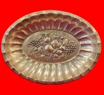 Centro de mesa década de 1970, em metal espessurado a prata, com bordas caneladas e um centro decorado com frutas em relevos. Medida: 5cm x 29cmx 22cm.