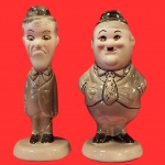 COLECIONISMO - Par representando "O Gordo e o Magro" (Oliver Hardy e Stan Laurel) Bonecos colecionáveis em faiança, vitrificados e pintados à mão. Obs. no estado, com colagens. Medida: 18cm.