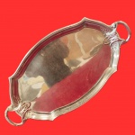 Antiga Bandeja em formato oval, com bordas ornamentadas com detalhes de folhas e pergaminhos, Confeccionada metal espessurado a prata. Medida: 62cmm x 35cm.
