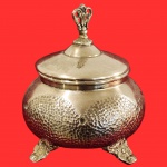 Bomboniere vintage anos 50, confeccionada em metal espessurado a prateado, com detalhes em relevo em seu bojo, encimada por um elegante tripé ricamente ornamentado no padrão de arabescos em relevos. Medida: 19cm x 15cm.