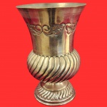 Vaso bojudo decorado em seu corpo bojudo decorado por caneluras em espiral e decoração no padrão de flores nas bordas, em metal espessurado a prata. Medida: 21cm x 14cm.