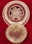 CRSITAL - Duas pecas, sendo um prato decorado por flor em relevo ao centro e bordas caneladas confeccionado em monobloco de cristal. E uma Bonboniere em formato circular, em demi cristal com bordas recortadas. Medida maior: 22cm x 9cm.