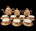 PORCELANA JAPONESA - Antigo Conjunto Oriental "dragonware",  em fina porcelana "casca de ovo", ricamente decorada no estilo "dragonware"  decoração de dragões em alto relevos, conjunto constando seis xícaras com seus respectivos pires, uma manteigueira dois bules chá e café e leiteira.