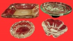Miscelânea/lote contendo quatro cinzeiros,  confeccionados em monobloco de pesado vidro, sendo dois de mão e dois de mesa. Medida maior: 22cm x 4cm, menor: 12cm x 4cm.