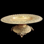 Magnifico Centro de mesa, do incio do século XX no estilo clássico, decorado em arabescos, elevado por quatros pés ornamentados, em metal espessurado a prata. Medida: 36cm x 15cm.