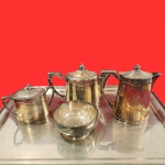 MAPPIN&WEBB'S - Conjunto de chá e café, do inicio do século, sendo dois boles de chá e café,  um açucareiro e uma biscoiteira, peças marcadas com monograma central, em metal espessurado a prata. Medida maior: 17cm x 17cm. Obs nao acompanha bandeja da foto.