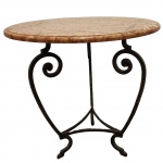 Mesa redonda, com tampo em mármore Rosso Verona, com base de ferro forjado, decorado em vazado no padrão de volutas. Medida: alt 67cm.