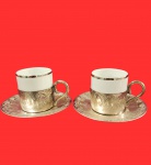 PORCELANA - Par de xícaras de cafézinho, com pires decorado em relevo em metal espessurado a prata.